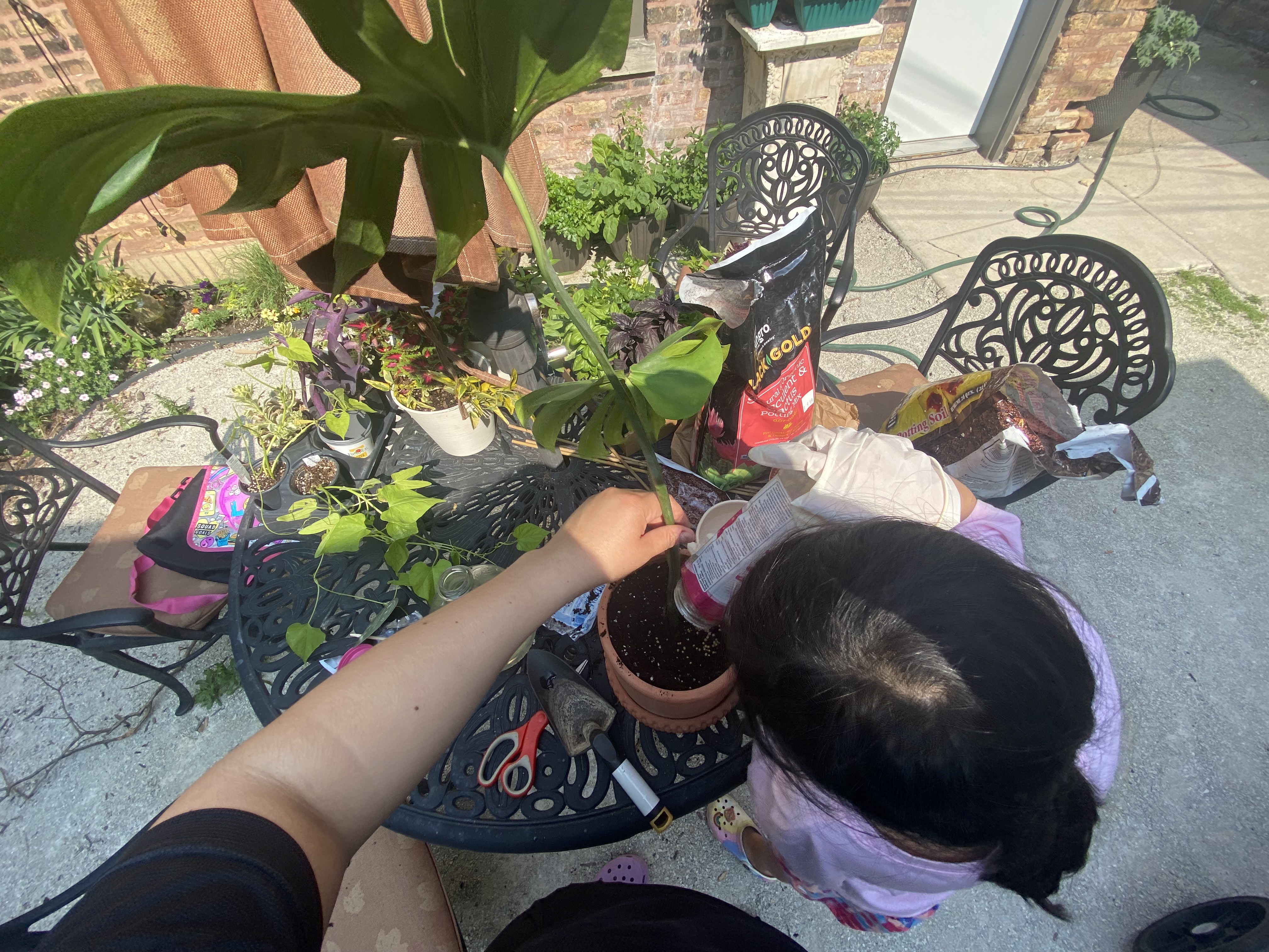 Karla and her daughter potting plants together outdoors